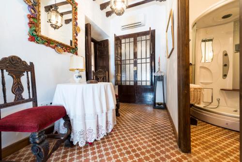 a room with a table and a chair and a mirror at Hotel Rural Tia Pilar in Almagro