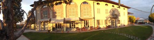 a large yellow building with a lawn in front of it at Locanda del Boscogrande in Montegrosso dʼAsti