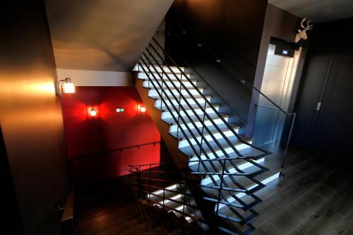 a spiral staircase in a building with a red wall at Le Comptoir du Voyageur in Arbois