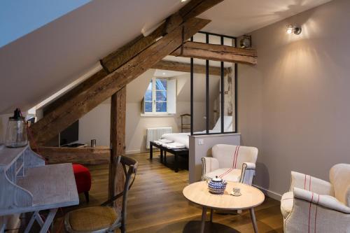 1 dormitorio y sala de estar con mesa y sillas. en Le Comptoir du Voyageur en Arbois