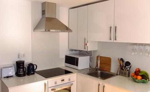 uma cozinha branca com um lavatório e um micro-ondas em Traditional Lisbon Madragoa Studio em Lisboa