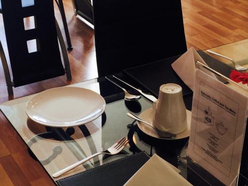 a glass table with utensils on top of it at Beechwood Ensuite Guest House in Ayr