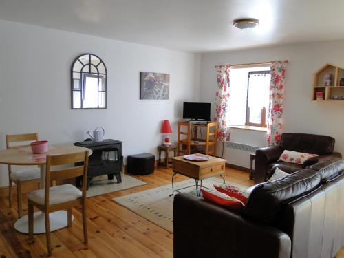 a living room with a couch and a table at Gites de la Motte Parent in Plouguenast Langast