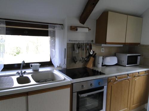 a small kitchen with a sink and a stove at Gites de la Motte Parent in Plouguenast Langast