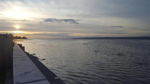 a view of a body of water with the sunset at Waters Edge in Penclawdd