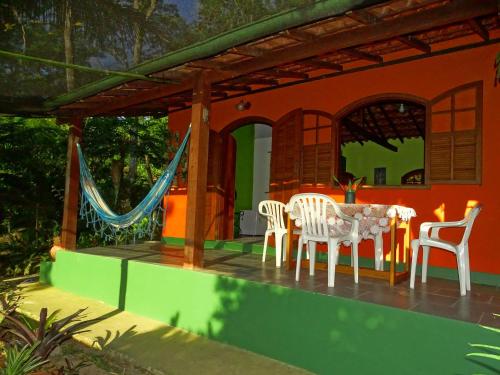 ein Haus mit einem Tisch und Stühlen auf einer Veranda in der Unterkunft Pousada Mar de Sonhos in Praia de Araçatiba