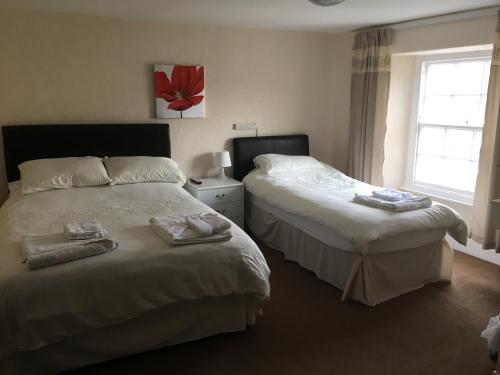 two beds in a hotel room with towels on them at The Buck Inn in Richmond