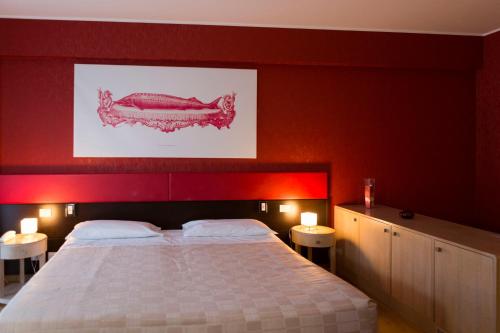 a bedroom with a large bed with red walls at Klass Hotel in Castelfidardo