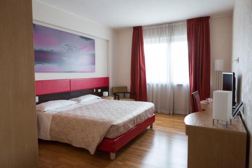 pokój hotelowy z łóżkiem i dużym oknem w obiekcie Klass Hotel w mieście Castelfidardo