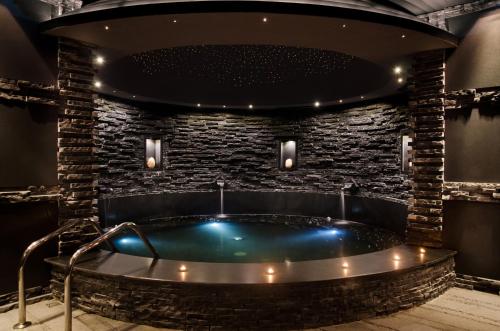 eine Whirlpool-Badewanne in einem Zimmer mit einer Steinmauer in der Unterkunft Villas Elenite Premium in Elenite