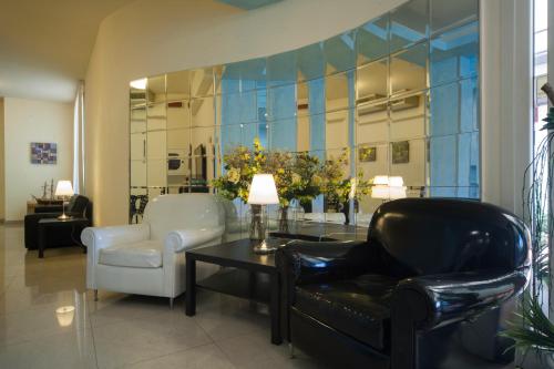 a living room with a couch and a table and a chair at Hotel Ricchi in Rimini