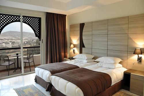 a hotel room with a large bed and a balcony at Menzeh Zalagh City Center in Fez