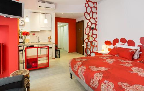 ミラノにあるAppartamento Rosso a Milano, tranquillo, vicino allo IEOのベッドルーム1室(赤いベッド1台付)、キッチンが備わります。