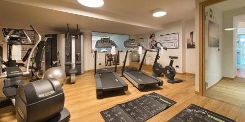a gym with treadmills and ellipticals in a room at Hotel Baita Montana in Livigno