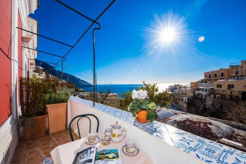 a table on a balcony with a view of the ocean at Dimora del Podestà in Positano