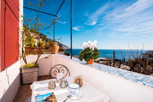 a table on a balcony with a view of the ocean at Dimora del Podestà in Positano