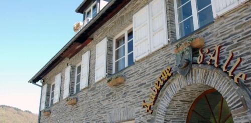 a brick building with a sign on the side of it at Hotel Auberge D'Alle in Alle