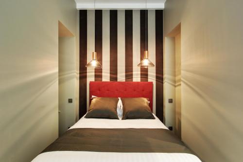 a bedroom with a bed with a red headboard at Milestay Opera Lafayette - Serviced Apartment in Paris