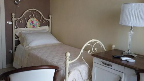 a bedroom with a bed and a desk with a lamp at Daphnae House in Palma di Montechiaro