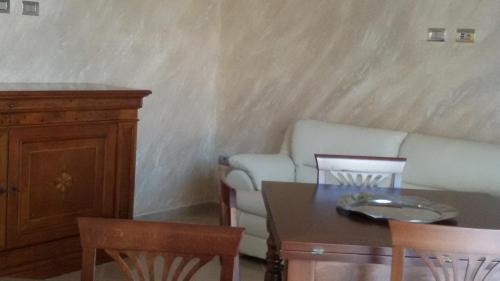 a living room with a couch and a table and chairs at Daphnae House in Palma di Montechiaro