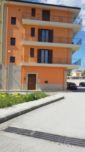 an orange building with a parking lot in front of it at Daphnae House in Palma di Montechiaro