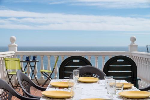 a table with yellow plates and glasses on a balcony at Casa Buenavista in Almuñécar