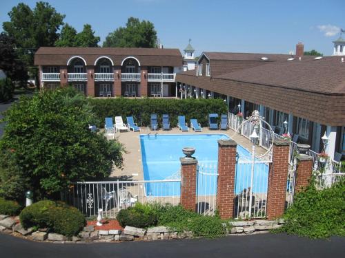 a hotel with a large swimming pool in front of a building at Lockport Inn and Suites in Lockport