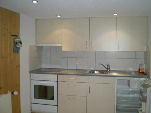 a kitchen with white cabinets and a sink at Säntisblick in Urnäsch