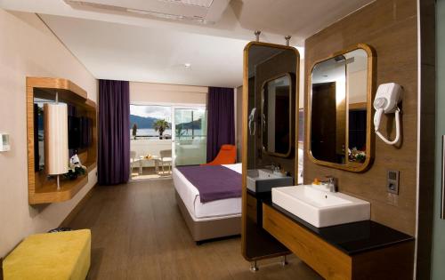 Casa De Maris Spa & Resort Hotel Adult Only 16 Plus في مرماريس: حمام مع حوض وسرير ومرآة