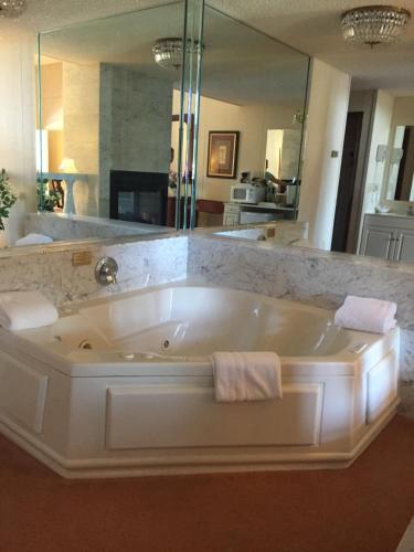 a large bath tub in a bathroom with a large mirror at Lockport Inn and Suites in Lockport