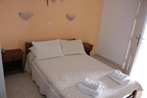 a bedroom with a bed with towels on it at Studios Angela Village in Lipsoi