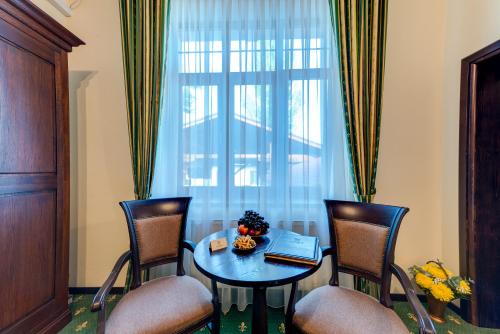 a room with a table and chairs and a window at Karlhof in Sebeş
