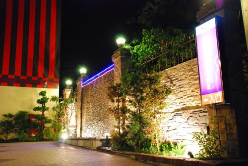 a brick wall with lights on it at night at Wei Feng Exquisite Motel Pintung Branch in Pingtung City