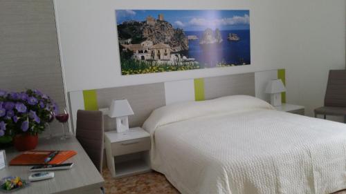a bedroom with a bed and a painting on the wall at Terrazze Villanova in Trapani