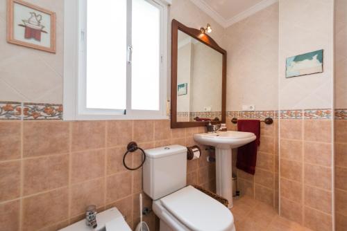 a bathroom with a toilet sink and a mirror at Casa Buenavista in Almuñécar