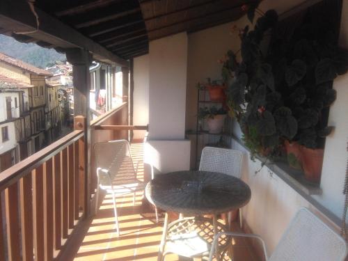 eine Terrasse mit einem Tisch und Stühlen auf dem Balkon in der Unterkunft El Humilladero in Mogarraz
