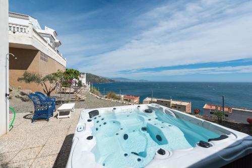 a hot tub on a patio overlooking the ocean at Casa Buenavista in Almuñécar