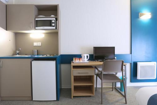 a room with a desk with a computer and a microwave at Apparteo Marseille in Marseille