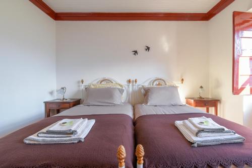 a bedroom with two beds with towels on them at Casa Cerro da Correia in Manteigas