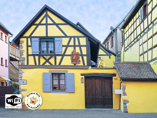 a yellow house with a black and yellow at Gîtes de la Maison Vigneronne, au Coeur de Ribeauvillé in Ribeauvillé