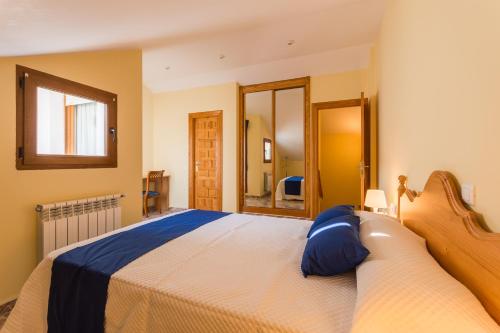 a bedroom with a large bed and a mirror at Apartamentos La Bolera in Isla