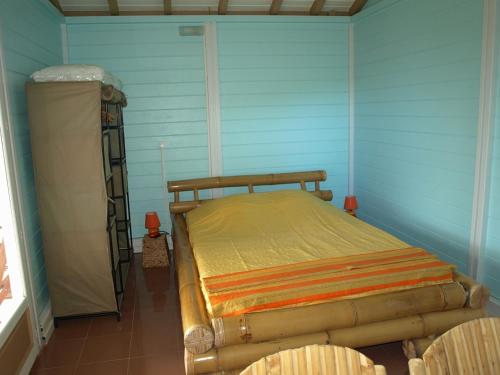 a bedroom with a bed in a blue room at Coco D'Iles in Terre-de-Bas