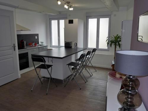 Maison Authier في بيريجو: مطبخ مع طاولة وكراسي في غرفة