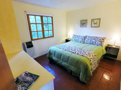 un dormitorio con una cama y una ventana en Camino de los Pioneros, en El Bolsón