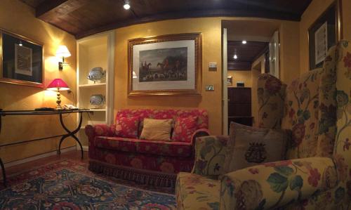 a living room with a couch and a chair at Hotel Gabbia D'Oro in Verona