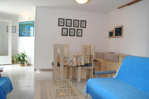 a living room with a table and a blue couch at Apartments Lada 1217 in Premantura