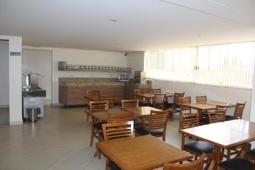 a dining room with wooden tables and chairs at Itupeva Plaza Hotel in Itupeva