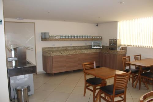 a kitchen with a table and chairs and a counter at Itupeva Plaza Hotel in Itupeva
