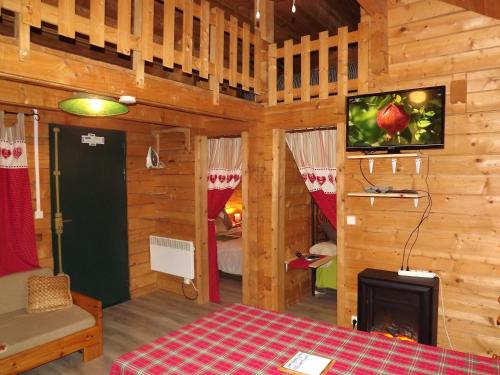 Zimmer mit einem Bett und einem TV in einer Hütte in der Unterkunft le chalet in Névy-lès-Dole