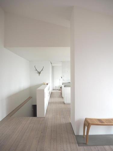 a room with white walls and a staircase with a table at Aufberg 1113 in Piesendorf